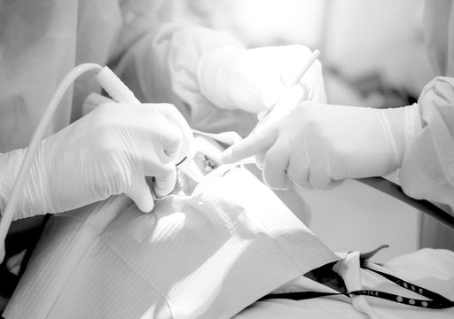 A patient with their face partially covered receiving dental treatment from a dentist.
