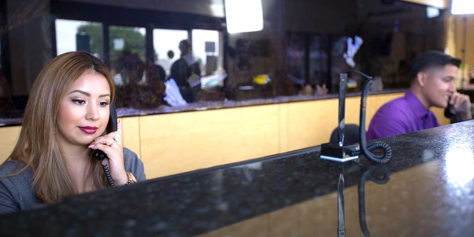 A woman and a man as the front desk staff.