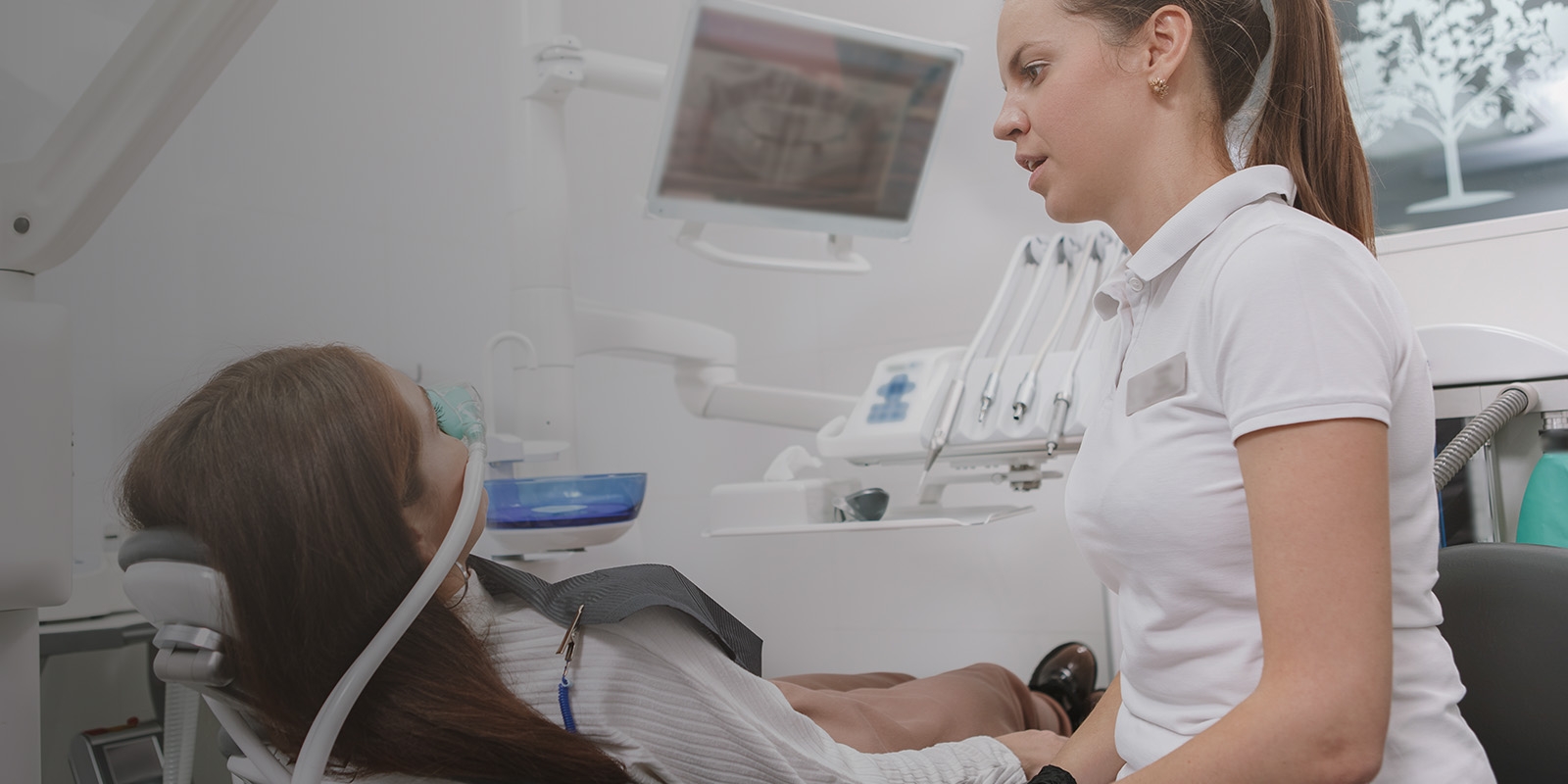 A woman at the dentist wearing a nasal mask for sedation or nitrous oxide.