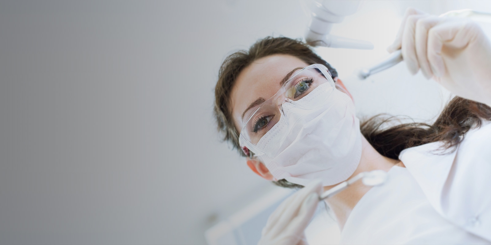 Close-up of a dentist wearing a mask looking at the camera.